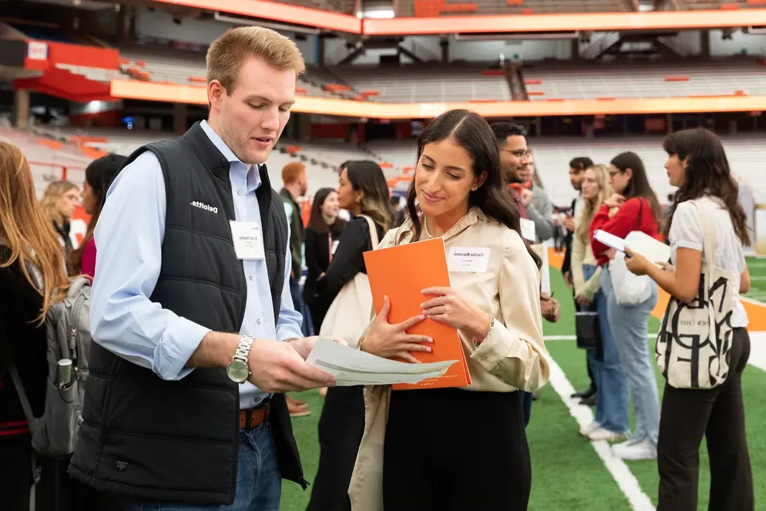 Student talking to Deloitte representative at career fair.